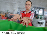 female worker ruefully showing her dirty hands. Стоковое фото, агентство Ingram Publishing / Фотобанк Лори