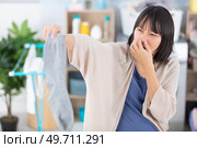 woman holding dirty stinky socks. Стоковое фото, агентство Ingram Publishing / Фотобанк Лори