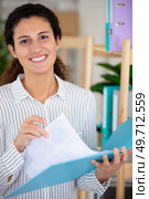 smiling young woman holding an open ring binder. Стоковое фото, агентство Ingram Publishing / Фотобанк Лори