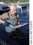 a fisherman holding a fish. Стоковое фото, агентство Ingram Publishing / Фотобанк Лори