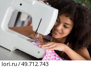 young woman sewing on modern sewing machine. Стоковое фото, агентство Ingram Publishing / Фотобанк Лори