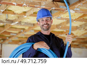 a builder with cables indoors. Стоковое фото, агентство Ingram Publishing / Фотобанк Лори
