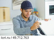 a male worker uses a key to screw furniture. Стоковое фото, агентство Ingram Publishing / Фотобанк Лори