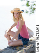 female tourist sitting on the seawall. Стоковое фото, агентство Ingram Publishing / Фотобанк Лори