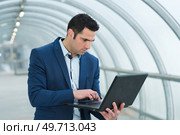 businessman using portable laptop in arched walkway. Стоковое фото, агентство Ingram Publishing / Фотобанк Лори