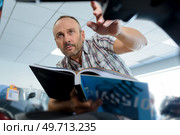 a man with catalogue indoors. Стоковое фото, агентство Ingram Publishing / Фотобанк Лори