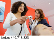 trainee hairdresser washing female clients hair. Стоковое фото, агентство Ingram Publishing / Фотобанк Лори