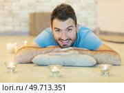 young man meditating on his living room. Стоковое фото, агентство Ingram Publishing / Фотобанк Лори