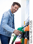 man filling gasoline fuel in car holding nozzle. Стоковое фото, агентство Ingram Publishing / Фотобанк Лори