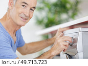 happy mature man doing the laundry chores. Стоковое фото, агентство Ingram Publishing / Фотобанк Лори