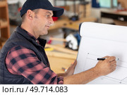 bearded handsome cabinetmaker at the tabletop with pencil. Стоковое фото, агентство Ingram Publishing / Фотобанк Лори