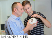 Student looking at a model with teacher. Стоковое фото, агентство Ingram Publishing / Фотобанк Лори