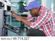 a technician is checking a printer. Стоковое фото, агентство Ingram Publishing / Фотобанк Лори