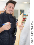 young man holding wood by a flipchart. Стоковое фото, агентство Ingram Publishing / Фотобанк Лори