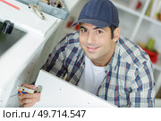 man fixing the cupboard door. Стоковое фото, агентство Ingram Publishing / Фотобанк Лори