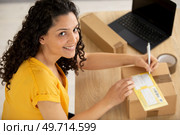 delivery mail shipping woman writing on box. Стоковое фото, агентство Ingram Publishing / Фотобанк Лори
