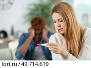 sad woman and with pregnancy test in bedroom. Стоковое фото, агентство Ingram Publishing / Фотобанк Лори