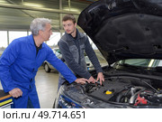 student with instructor repairing a car during apprenticeship. Стоковое фото, агентство Ingram Publishing / Фотобанк Лори