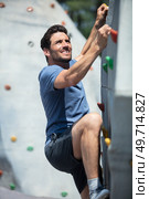 young man climbing wall rock outdoors. Стоковое фото, агентство Ingram Publishing / Фотобанк Лори