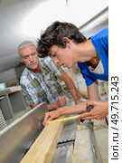 a carpenter watching apprentice work. Стоковое фото, агентство Ingram Publishing / Фотобанк Лори