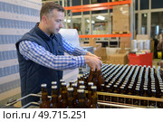 brewery worker arranging the bottles. Стоковое фото, агентство Ingram Publishing / Фотобанк Лори
