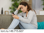 woman distressed by message sent on smartphone. Стоковое фото, агентство Ingram Publishing / Фотобанк Лори