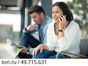 happy woman using smart phones in a train station. Стоковое фото, агентство Ingram Publishing / Фотобанк Лори