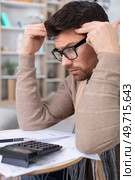 man troubled doing his home accounts. Стоковое фото, агентство Ingram Publishing / Фотобанк Лори