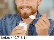 young man eats yogourt. Стоковое фото, агентство Ingram Publishing / Фотобанк Лори