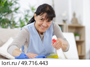 happy woman cleaning with a spray detergent. Стоковое фото, агентство Ingram Publishing / Фотобанк Лори