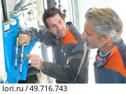 mechanics are looking at equipment. Стоковое фото, агентство Ingram Publishing / Фотобанк Лори