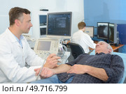 male doctor with male patient undergoing arm echography. Стоковое фото, агентство Ingram Publishing / Фотобанк Лори
