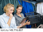 women checks availability of goods by using the touch pad. Стоковое фото, агентство Ingram Publishing / Фотобанк Лори