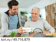 nice elderly father receive present from his grown up son. Стоковое фото, агентство Ingram Publishing / Фотобанк Лори