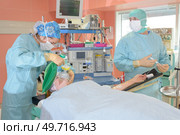 surgeons at work operating in surgical theatre. Стоковое фото, агентство Ingram Publishing / Фотобанк Лори