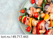 Appetizing meat kebab with vegetables marinated in herbs. Copy space. Raw shashlik and vegetables. Стоковое фото, агентство Ingram Publishing / Фотобанк Лори