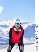 Young healthy woman in outerwear and sunglasses resting while leaning on knees against mountains in snow. Female runner in warm clothes in winter. Стоковое фото, агентство Ingram Publishing / Фотобанк Лори