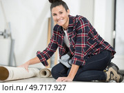happy woman is unrolling a new carpet. Стоковое фото, агентство Ingram Publishing / Фотобанк Лори