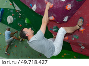 man climber on artificial climbing wall in bouldering gym. Стоковое фото, агентство Ingram Publishing / Фотобанк Лори