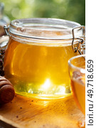 beautiful fresh natural golden  linden honey in big glass jar  at wooden tray in beautiful sunny light. close up. Стоковое фото, агентство Ingram Publishing / Фотобанк Лори