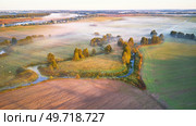 Warm sunny September morning. Autumn beautiful fog landscape. Small river curves in trees. Bright sunny misty riverside. Scenic view of rural sunrise. Village in Agriculture fields. Europe, Belarus. Стоковое фото, агентство Ingram Publishing / Фотобанк Лори