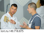 a painter talking with apprentice. Стоковое фото, агентство Ingram Publishing / Фотобанк Лори