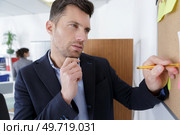 man writing a memo on the board. Стоковое фото, агентство Ingram Publishing / Фотобанк Лори