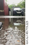 A car is parked in a parking lot with a puddle of water on the ground. Стоковое видео, видеограф Ярославский Максим / Фотобанк Лори