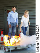 woman demonstrating how to use a fire extinguisher. Стоковое фото, агентство Ingram Publishing / Фотобанк Лори