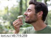 young man with a beard smelling mushroom. Стоковое фото, агентство Ingram Publishing / Фотобанк Лори