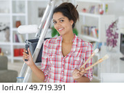 young indifferent beautiful woman holding paint brushes. Стоковое фото, агентство Ingram Publishing / Фотобанк Лори