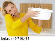 upset woman calling insurance for water leaks. Стоковое фото, агентство Ingram Publishing / Фотобанк Лори
