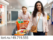 man pushes shopping cart with woman. Стоковое фото, агентство Ingram Publishing / Фотобанк Лори