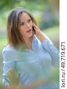 Angry woman outdoors on cellphone. Стоковое фото, агентство Ingram Publishing / Фотобанк Лори